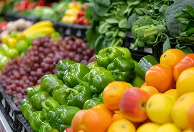 Produce at a grocery store, focus is on bell peppers.